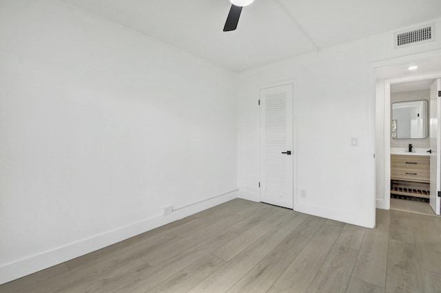 unfurnished bedroom with light wood-type flooring, a closet, ceiling fan, and sink