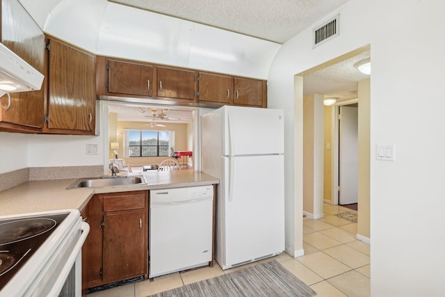 kitchen with white appliances, light tile patterned floors, ceiling fan, a textured ceiling, and sink