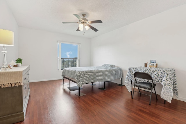 bedroom featuring a textured ceiling, ceiling fan, and dark hardwood / wood-style floors