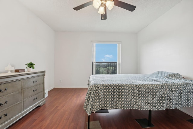 bedroom with a textured ceiling, ceiling fan, and dark hardwood / wood-style flooring