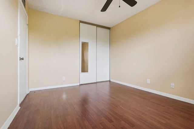 unfurnished bedroom featuring ceiling fan, dark hardwood / wood-style flooring, and a closet