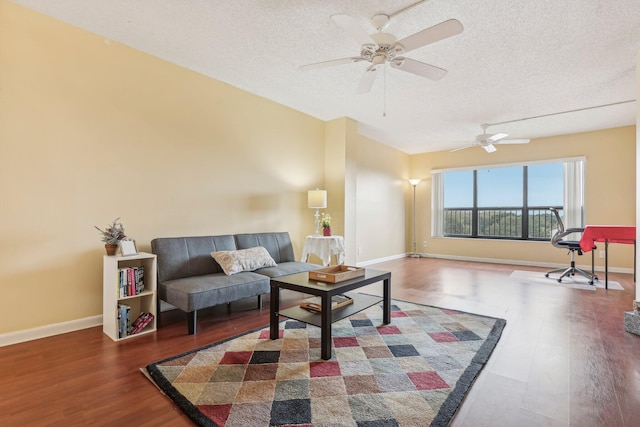 living room with a textured ceiling, dark hardwood / wood-style flooring, and ceiling fan