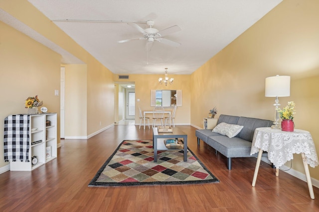 living room featuring ceiling fan with notable chandelier and dark hardwood / wood-style floors