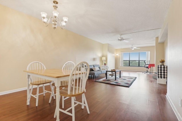 dining space featuring a textured ceiling, dark wood-type flooring, and ceiling fan with notable chandelier