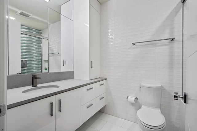 bathroom featuring vanity, tile walls, toilet, and tile patterned flooring