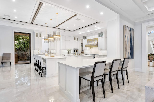 kitchen featuring white cabinets, a large island, pendant lighting, and a breakfast bar