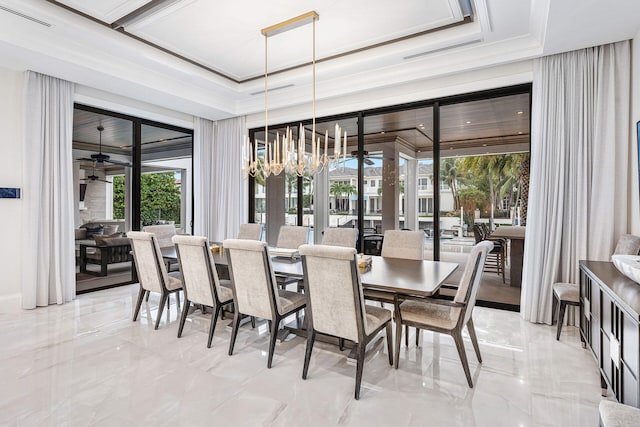 dining area featuring ceiling fan with notable chandelier, a raised ceiling, and a wealth of natural light