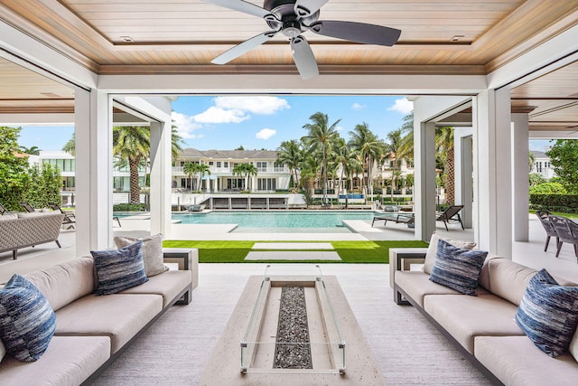 exterior space featuring ceiling fan and an outdoor living space with a fire pit