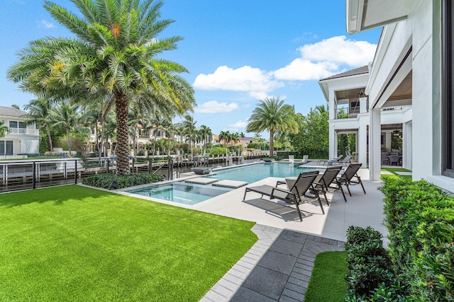 view of pool with an in ground hot tub, a yard, and a patio