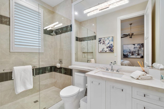 bathroom with tile patterned floors, vanity, ceiling fan, toilet, and a shower with shower door