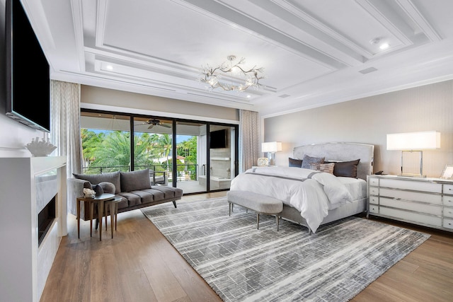 bedroom with access to outside, crown molding, wood-type flooring, a premium fireplace, and beamed ceiling