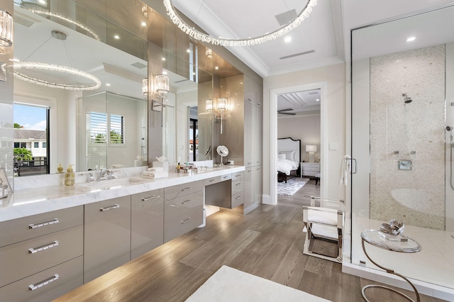 bathroom with an enclosed shower, vanity, crown molding, hardwood / wood-style flooring, and a notable chandelier