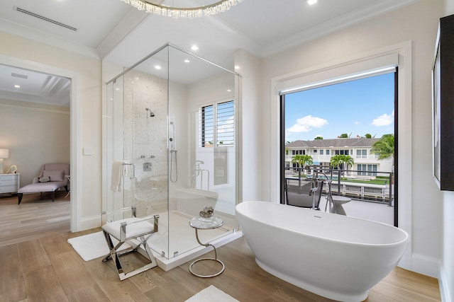 bathroom with wood-type flooring, crown molding, and independent shower and bath