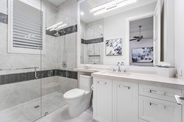 bathroom with ceiling fan, vanity, a shower with shower door, and toilet