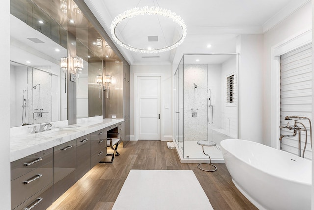 bathroom with crown molding, vanity, wood-type flooring, and shower with separate bathtub