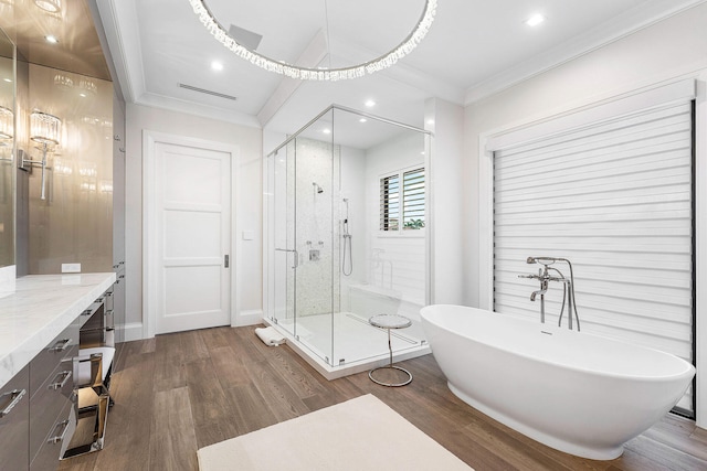 bathroom with vanity, separate shower and tub, wood-type flooring, and ornamental molding