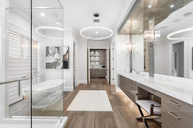 bathroom featuring a washtub, hardwood / wood-style floors, vanity, and ornamental molding