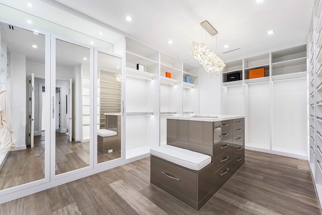 walk in closet featuring hardwood / wood-style flooring and a notable chandelier