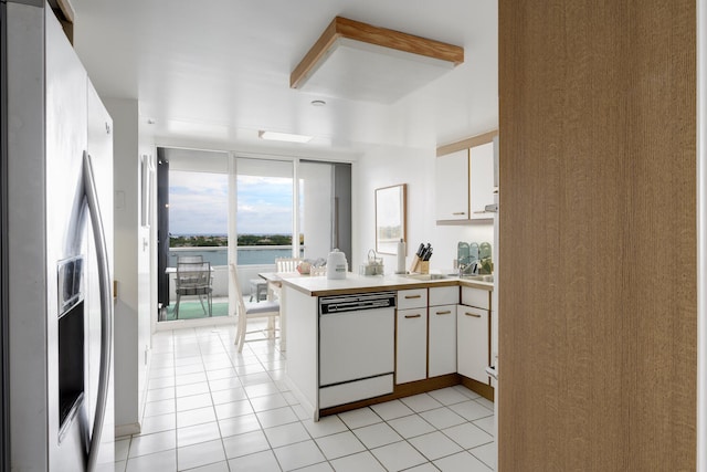 kitchen with white cabinetry, kitchen peninsula, stainless steel fridge, and white dishwasher