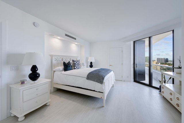 bedroom with light wood-type flooring and access to outside