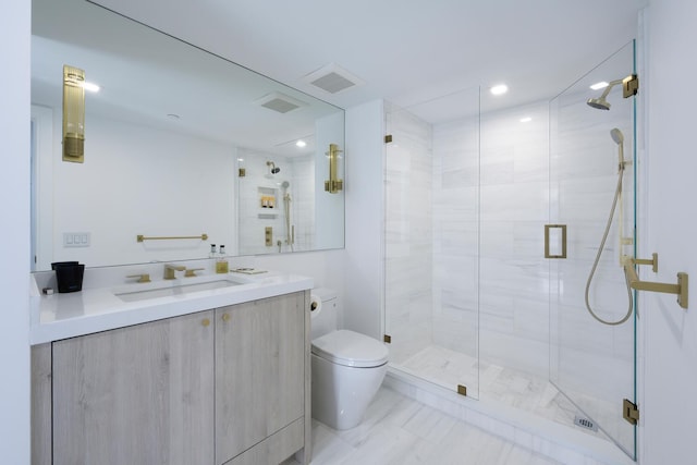 bathroom featuring a shower with door, vanity, and toilet