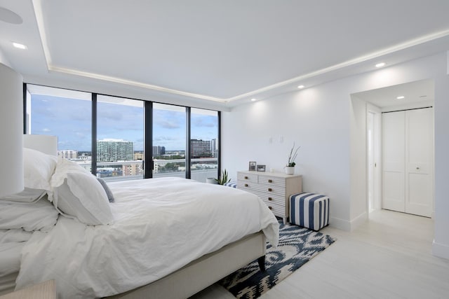 bedroom featuring expansive windows, a closet, and light hardwood / wood-style flooring