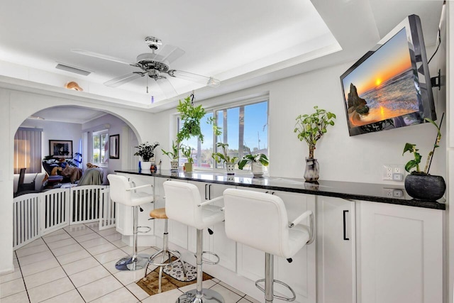 interior space with light tile patterned floors, plenty of natural light, and ceiling fan