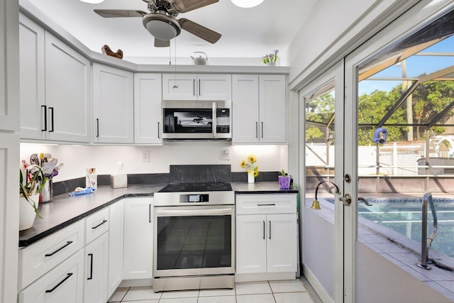 kitchen with white cabinetry, french doors, light tile patterned flooring, and stainless steel appliances