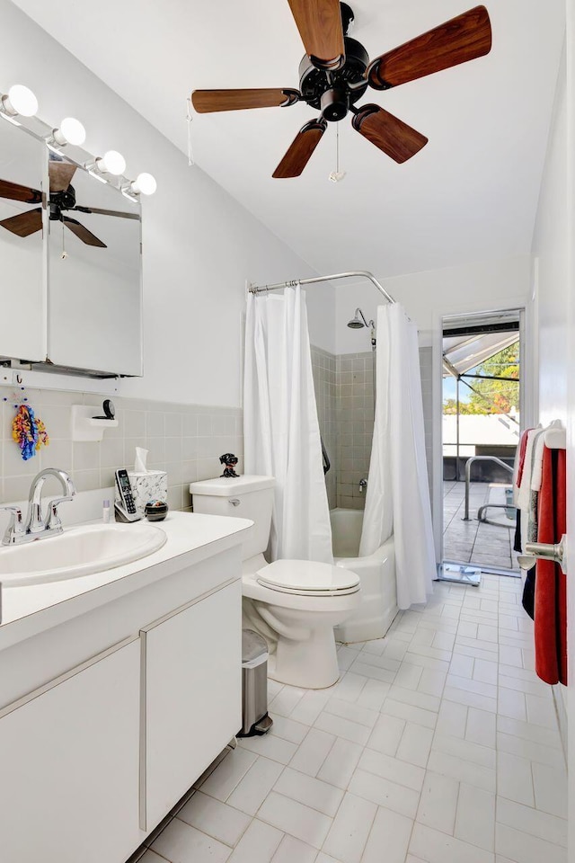 full bathroom featuring vanity, shower / bath combination with curtain, ceiling fan, toilet, and tile walls