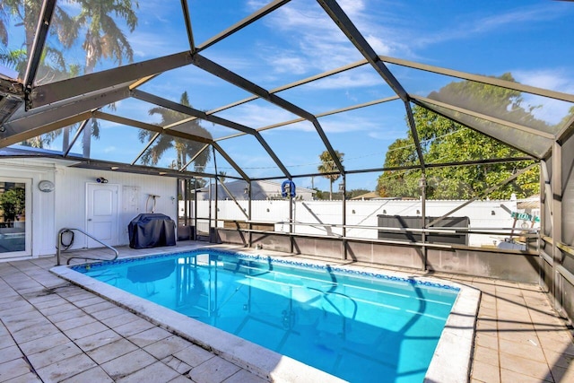 view of pool with a lanai, a patio area, and grilling area