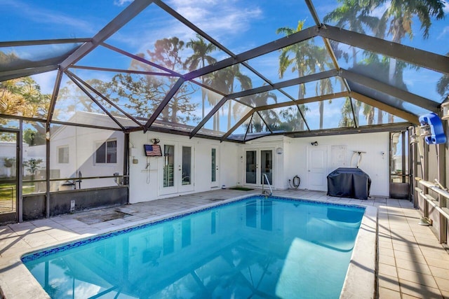 view of swimming pool featuring a lanai, grilling area, a patio area, and french doors