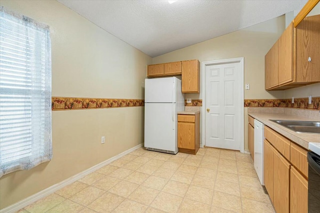 kitchen featuring white appliances, vaulted ceiling, plenty of natural light, and sink