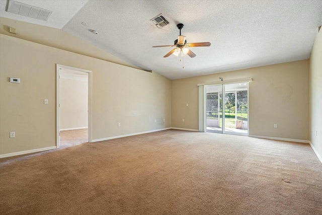 spare room featuring a textured ceiling, light colored carpet, vaulted ceiling, and ceiling fan