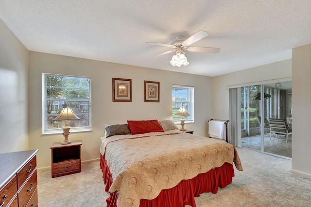 bedroom featuring light carpet, a textured ceiling, baseboards, and access to outside