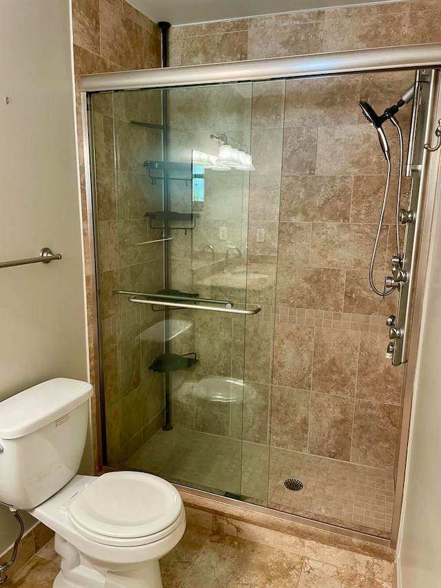 bathroom with toilet and a shower with shower door