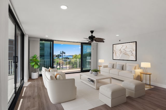 living room featuring wood-type flooring, expansive windows, and ceiling fan