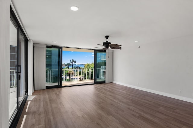 empty room featuring hardwood / wood-style floors, floor to ceiling windows, and ceiling fan