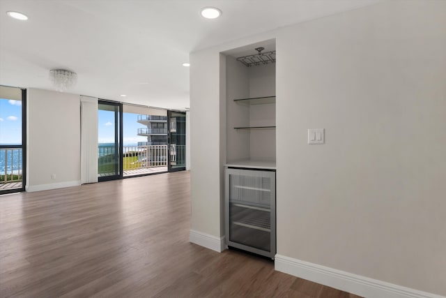 3400 S Ocean Blvd Unit 3Fii, Palm Beach, FL 33480 - spare room featuring wine cooler, wood finished floors, a wall of windows, recessed lighting, and built in shelves