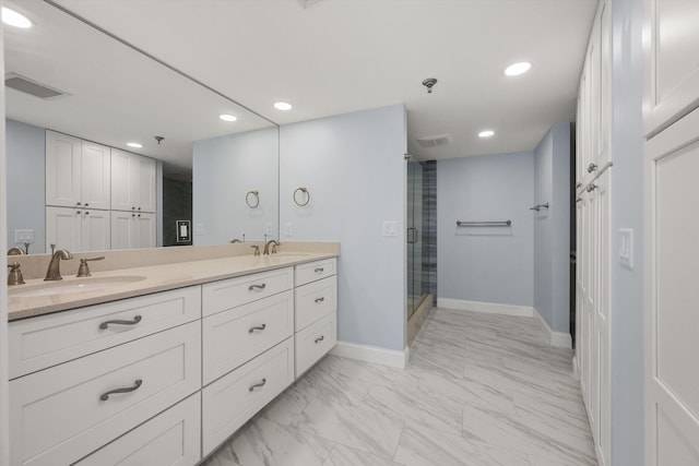 bathroom featuring a shower with door and vanity