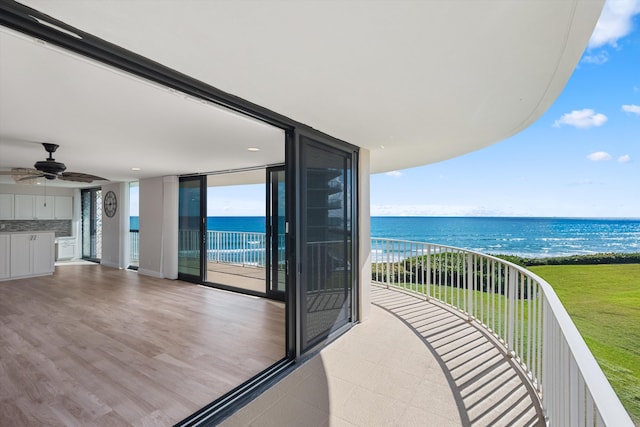 balcony with a water view and ceiling fan