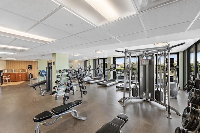 gym with a drop ceiling and expansive windows