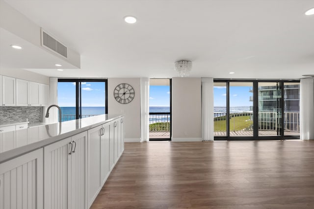 3400 S Ocean Blvd Unit 3Fii, Palm Beach, FL 33480 - kitchen featuring wood finished floors, open floor plan, white cabinets, a water view, and floor to ceiling windows