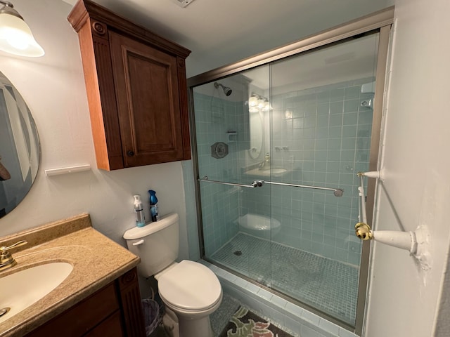 bathroom with vanity, toilet, and a shower with door