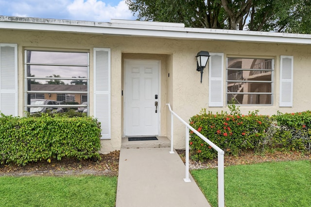 property entrance featuring a lawn