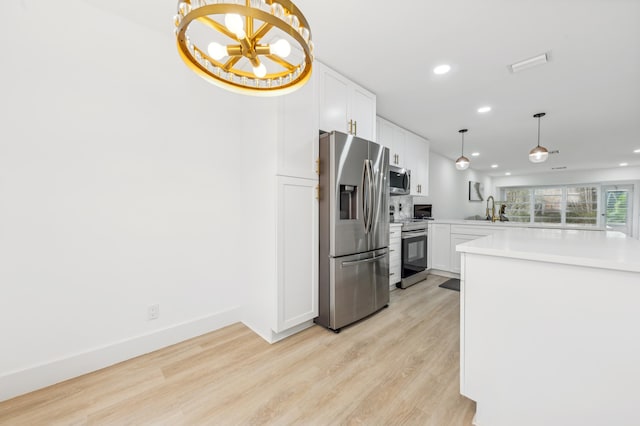 kitchen with pendant lighting, an inviting chandelier, light hardwood / wood-style flooring, appliances with stainless steel finishes, and white cabinetry