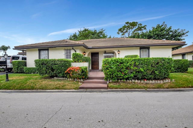 ranch-style home featuring a front lawn