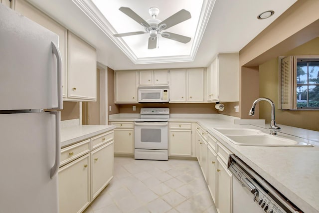 kitchen featuring white appliances, a raised ceiling, ceiling fan, sink, and cream cabinets