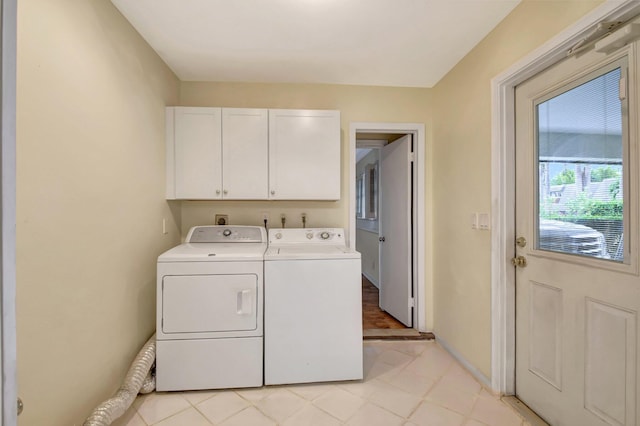 clothes washing area with cabinets and washer and dryer