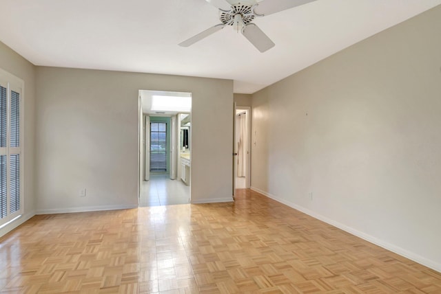 empty room with ceiling fan and light parquet floors