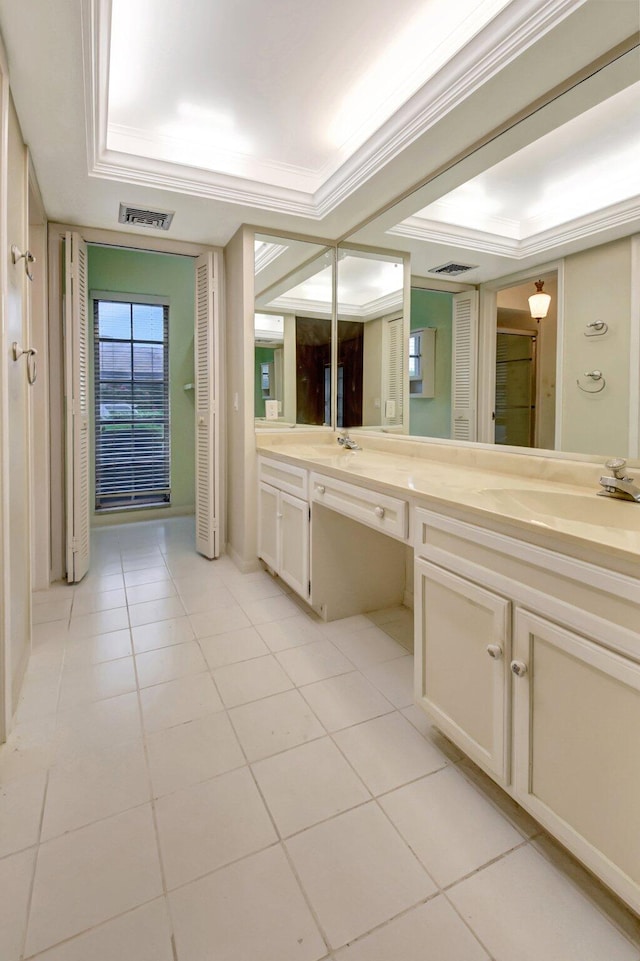 bathroom with tile patterned flooring, vanity, and a tray ceiling